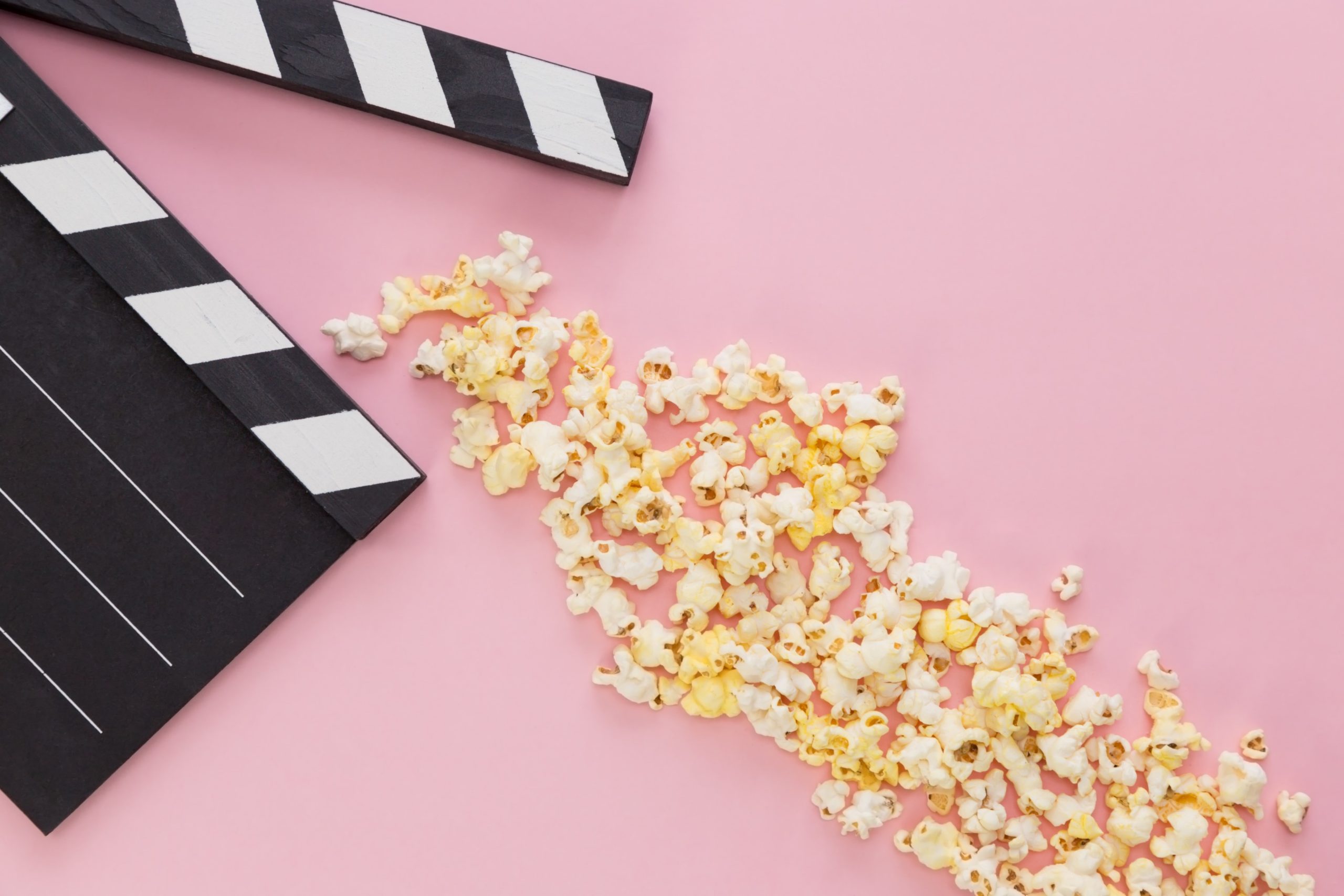 popcorn scattered beneath a movie film clap board