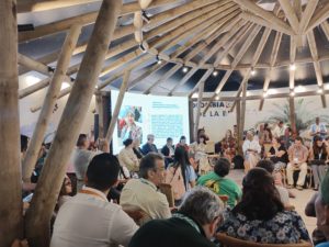 Group of people gathering for a conference at the Colombian Pavilion during COP16.