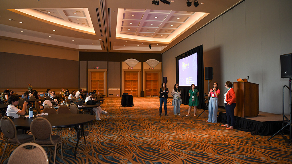 A group of speakers speak to an audience.