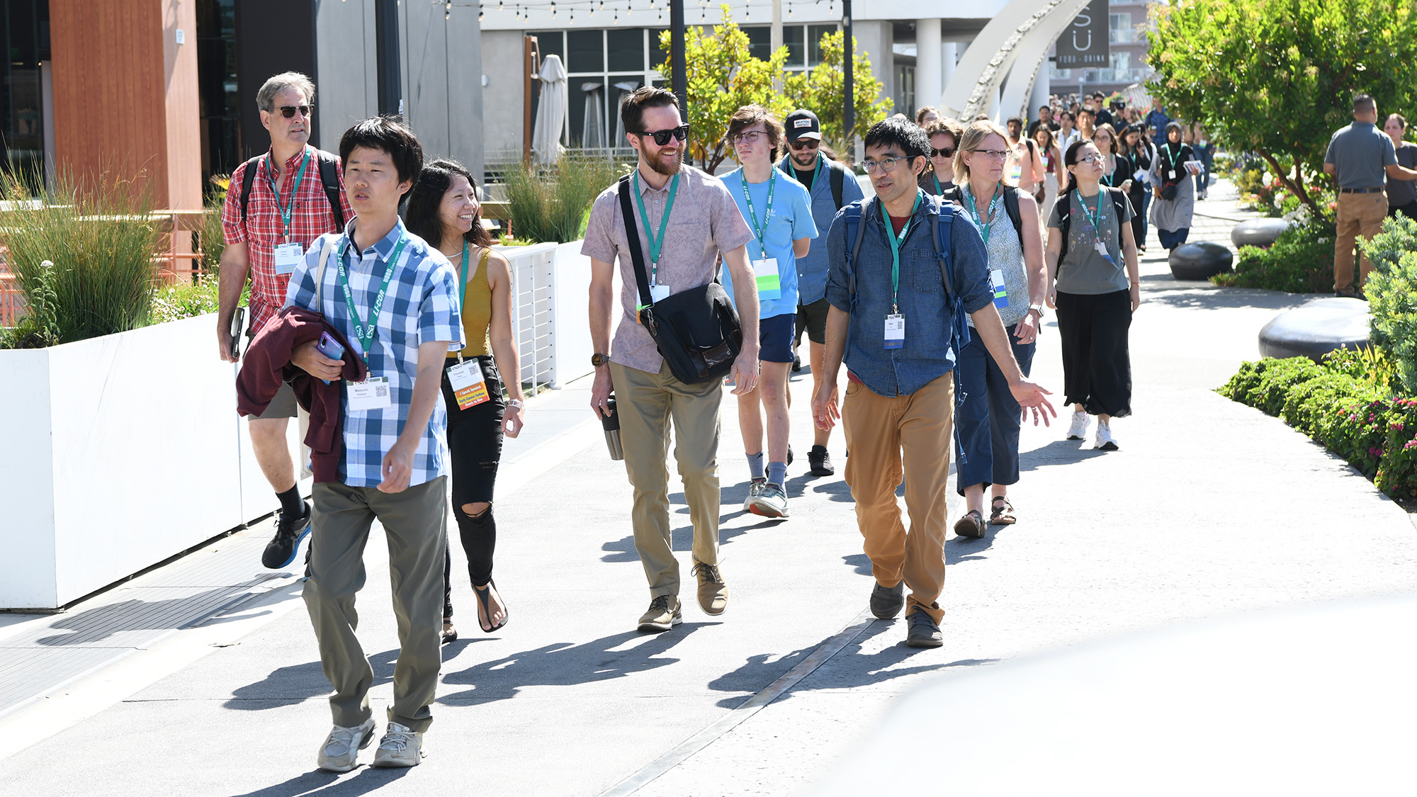 A group of about 100 meeting attendees walk to a session.