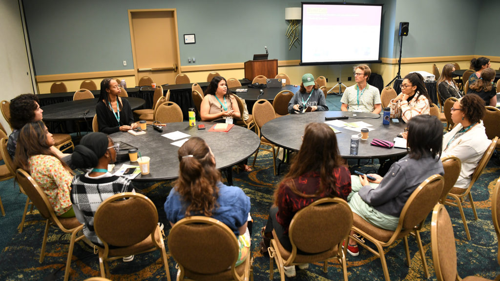 3 rounds tables contain groups discussing topics.