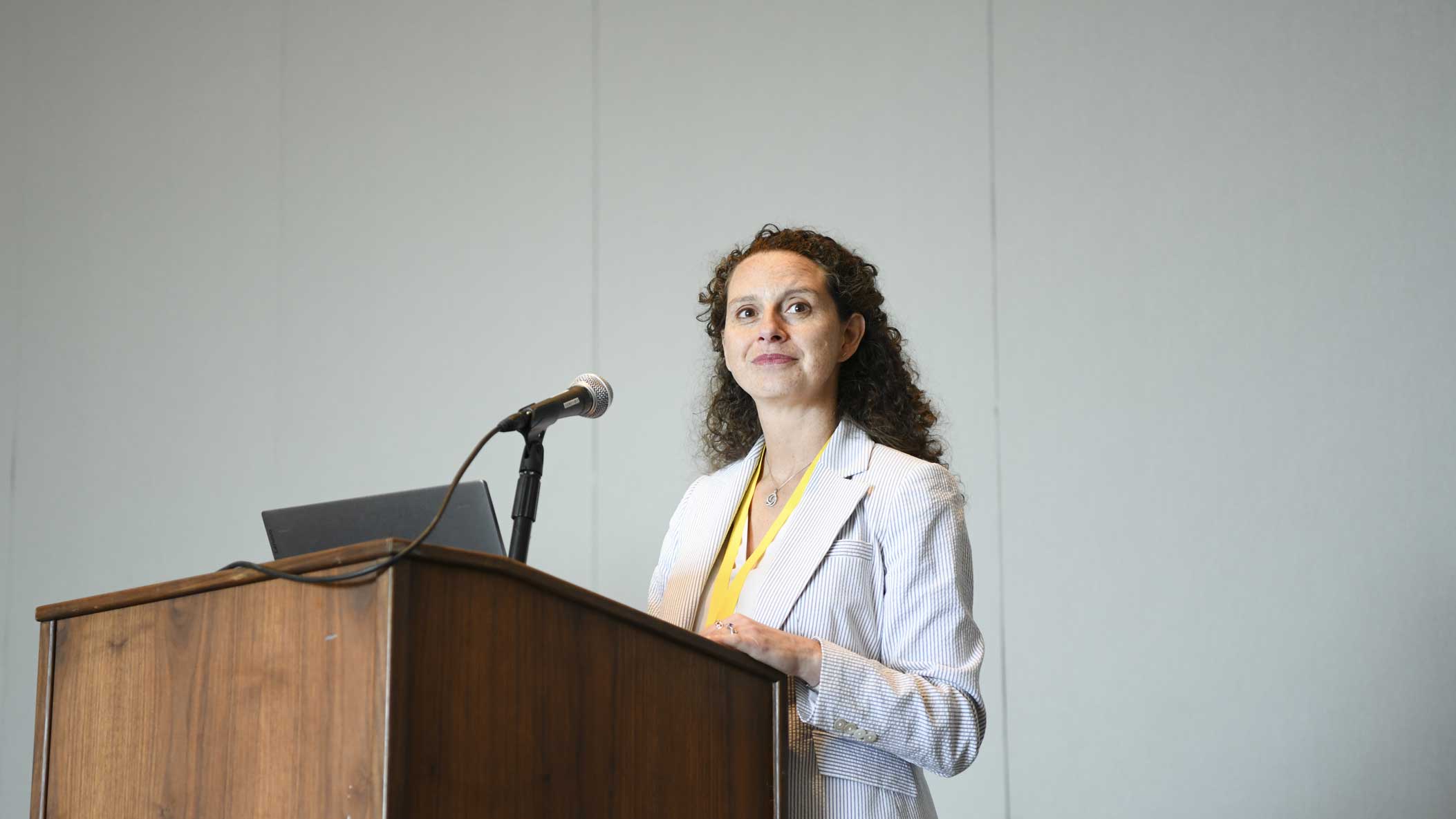 A speaker presents from a podium with a microphone.