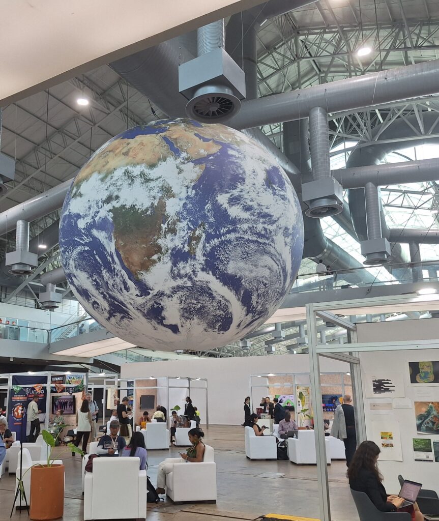A large globe of the Earth hangs in a convention center.