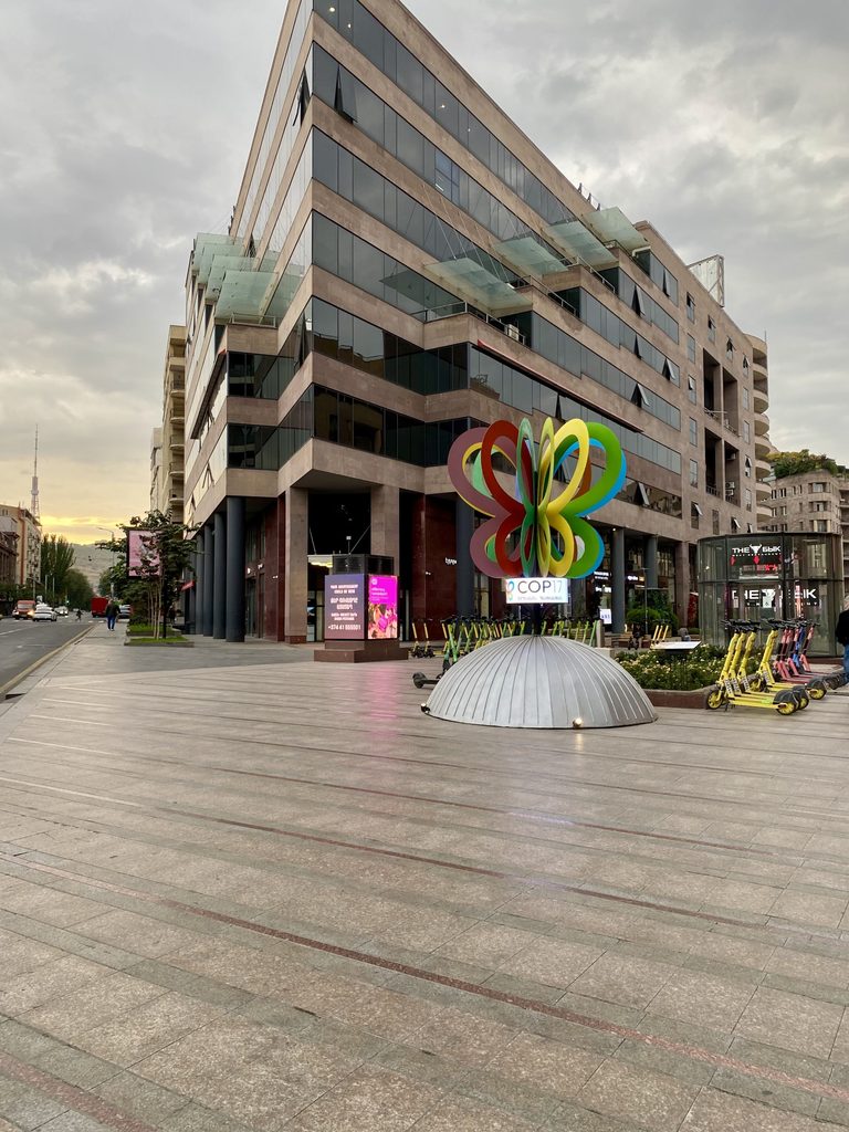 A butterfly sculpture stands in a city square.