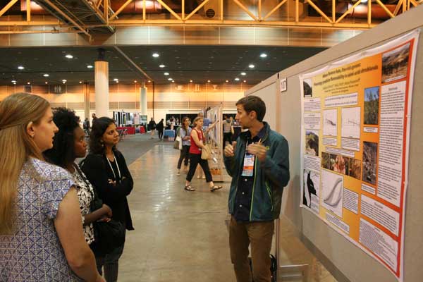 Photo: Attendees listen to a presenter at an ESA poster session.