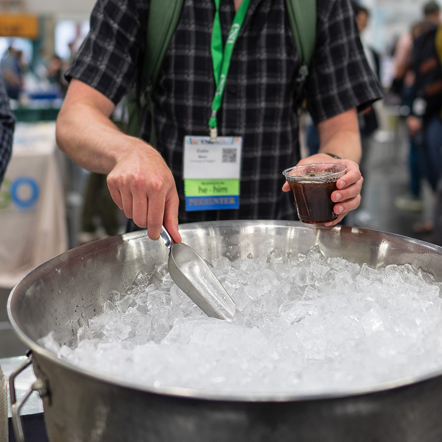 An attendee scoops ice for their beverage.
