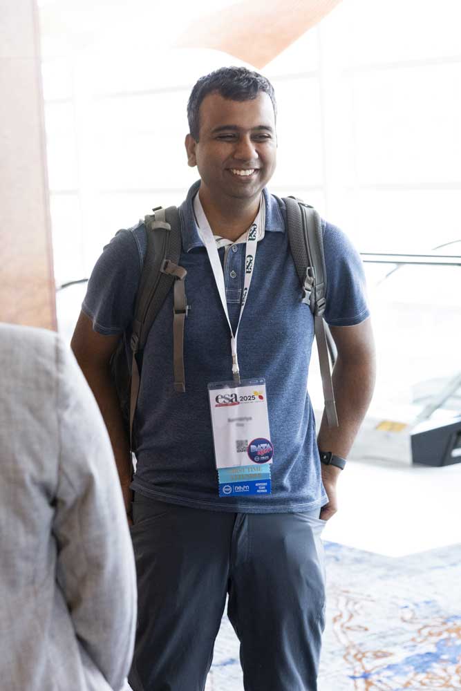 An attendee stands with a smile.