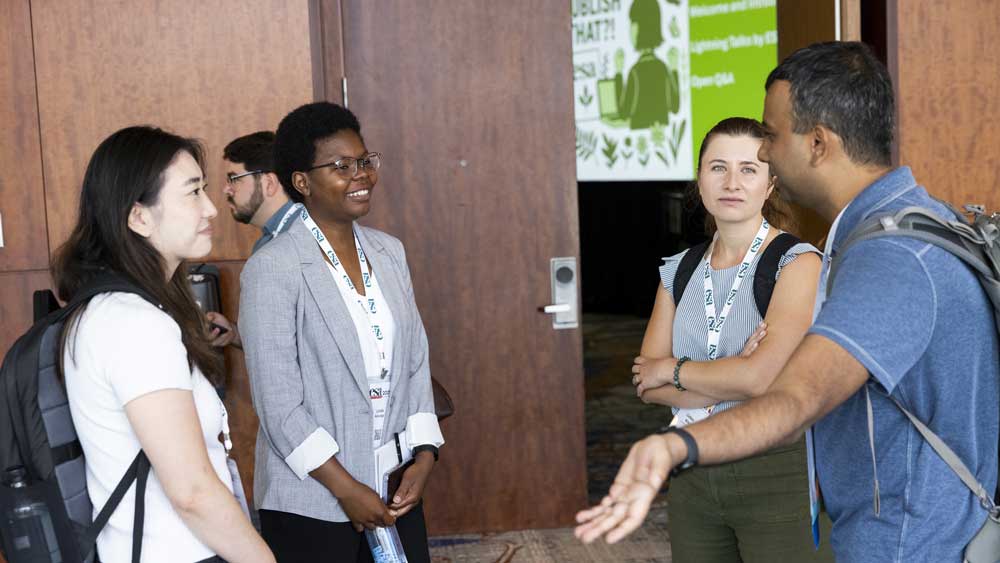 A group of four attendees chat.