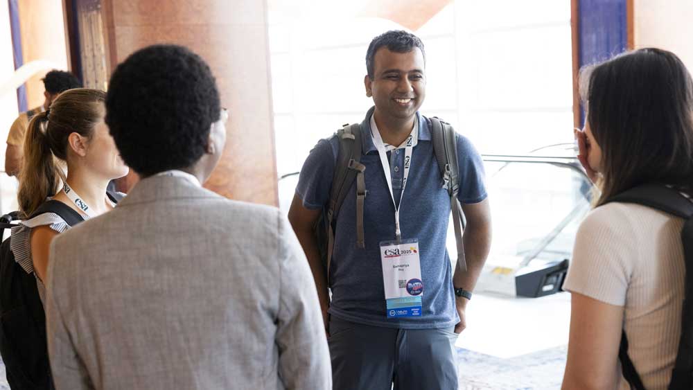A member of a group of attendees smiles.