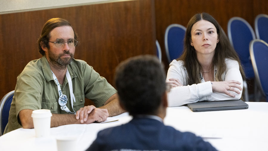 Two participants listen intently to a colleague.