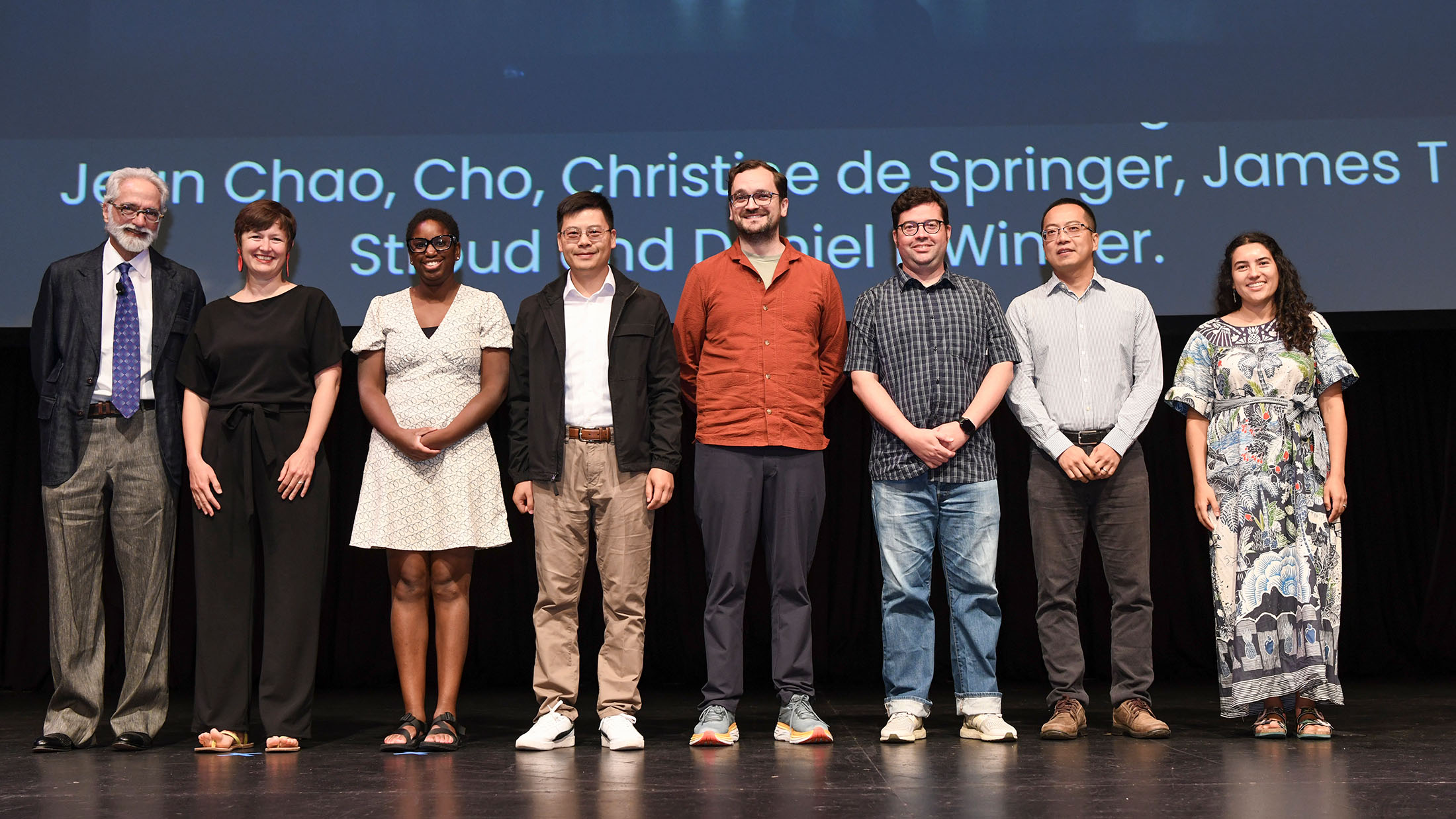A group of award winners receive their awards on stage.