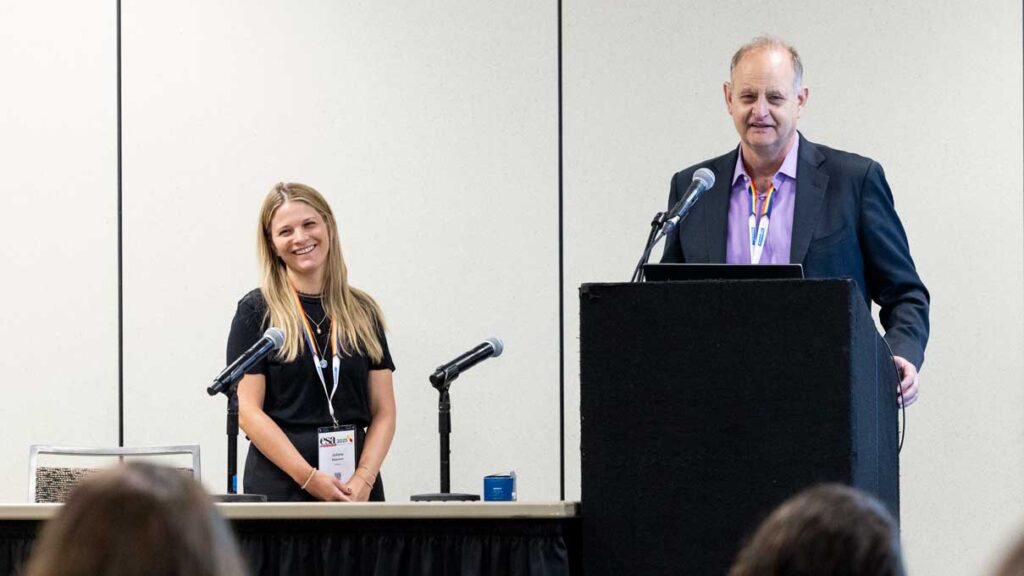 A man and woman present before an audience.