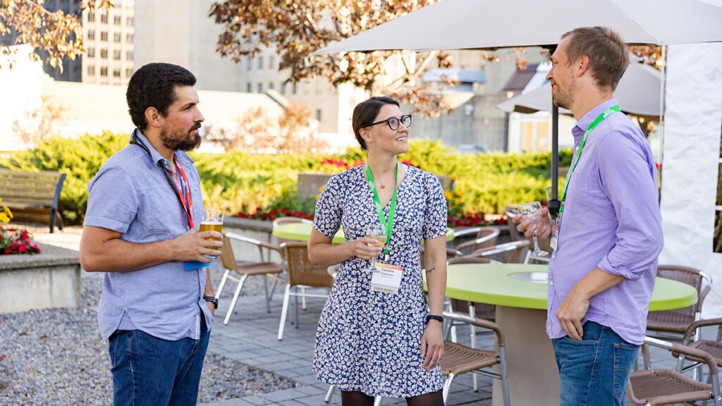Three participants chat during a social event.