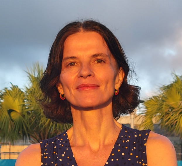 Picture of Maíra Uriarte standing before an overcast,   tropical backdrop. 