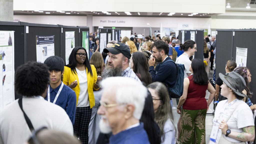 Long view of the convention center with dozens of ecologists looking at presenting posters.