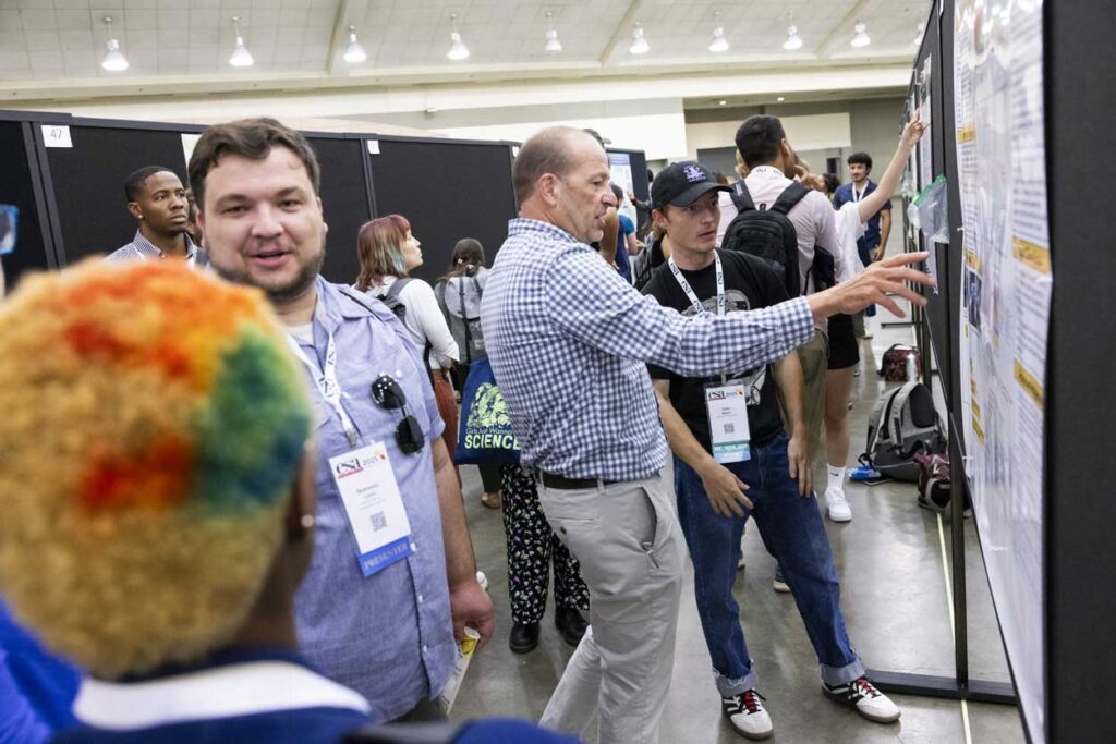 Attendees examine a posted poster.