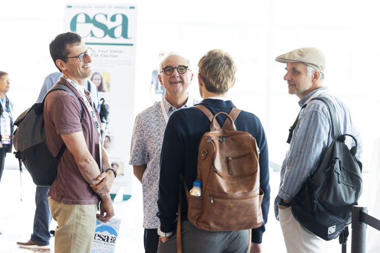 Osvaldo Sala chats with a few meeting attendees.