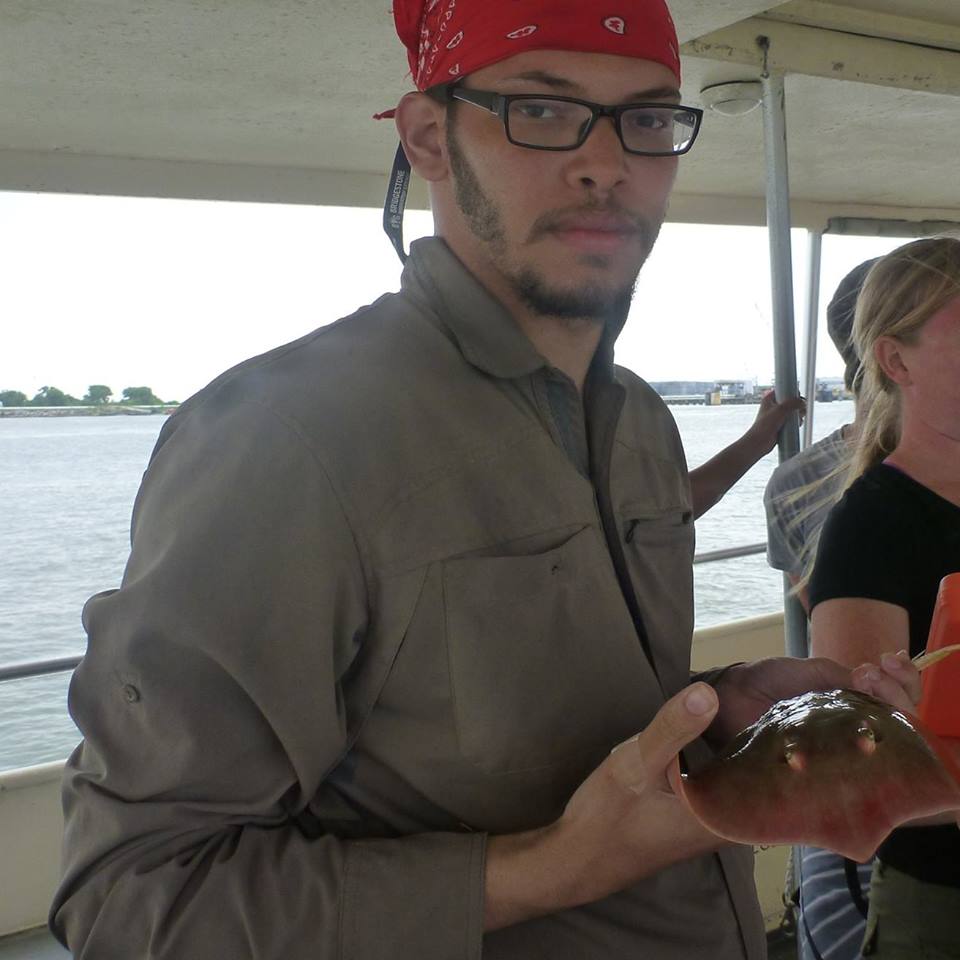 Man on a boat holds a ray.
