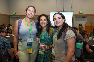 Three women and SEEDS attendees pose for a picture at the Annual Meeting.