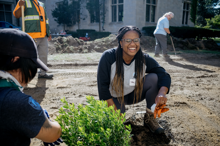 Image of Tiffany Jones laughing while working in a cooperative gardening effort.