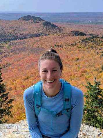 A winner smiles before the backdrop of an arid desert.
