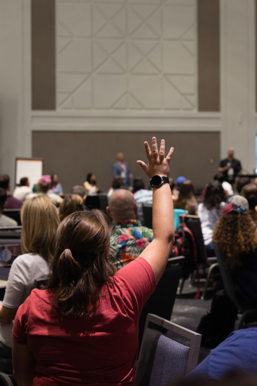 An audience member raises her hand.