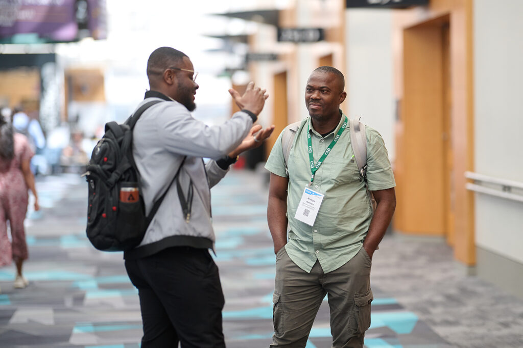Two men discuss a topic in the convention center hallway.