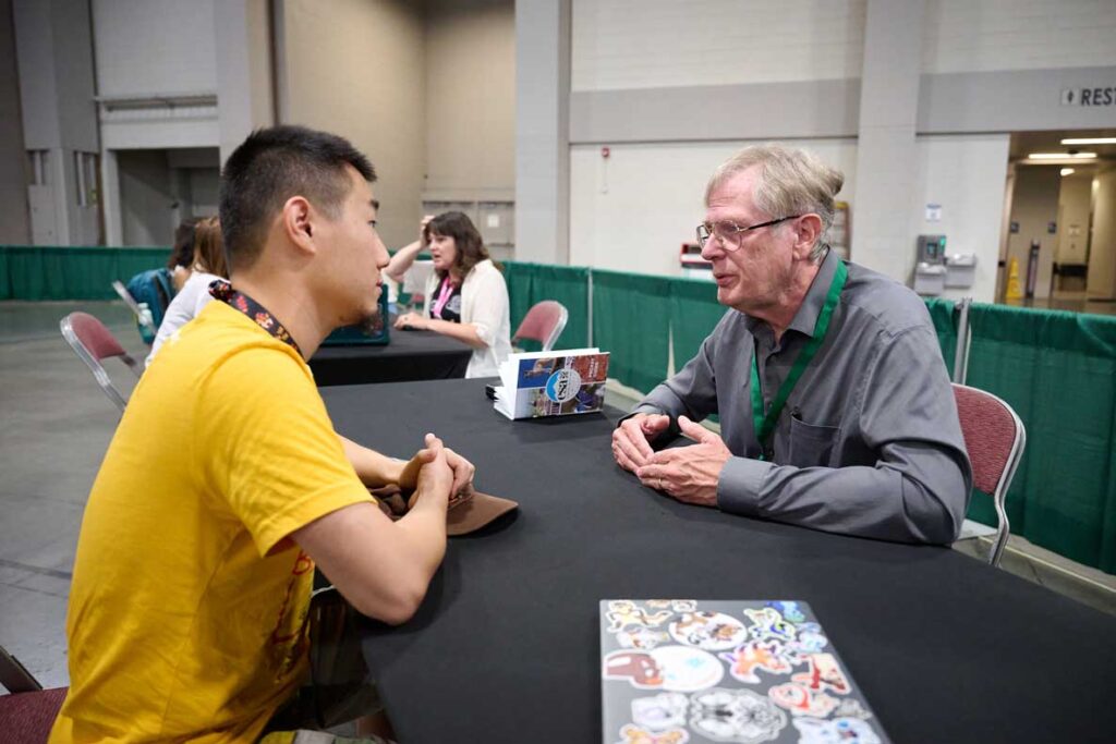 An older mentor and younger mentee discuss career paths. 