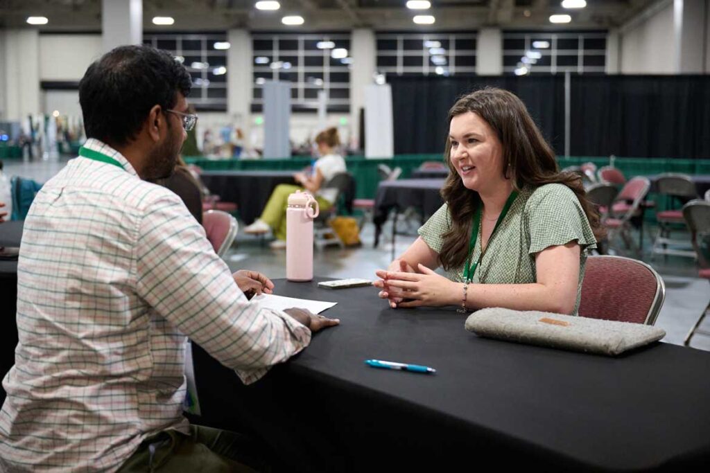 Two people discuss a topic in the career center at the annual meeting.