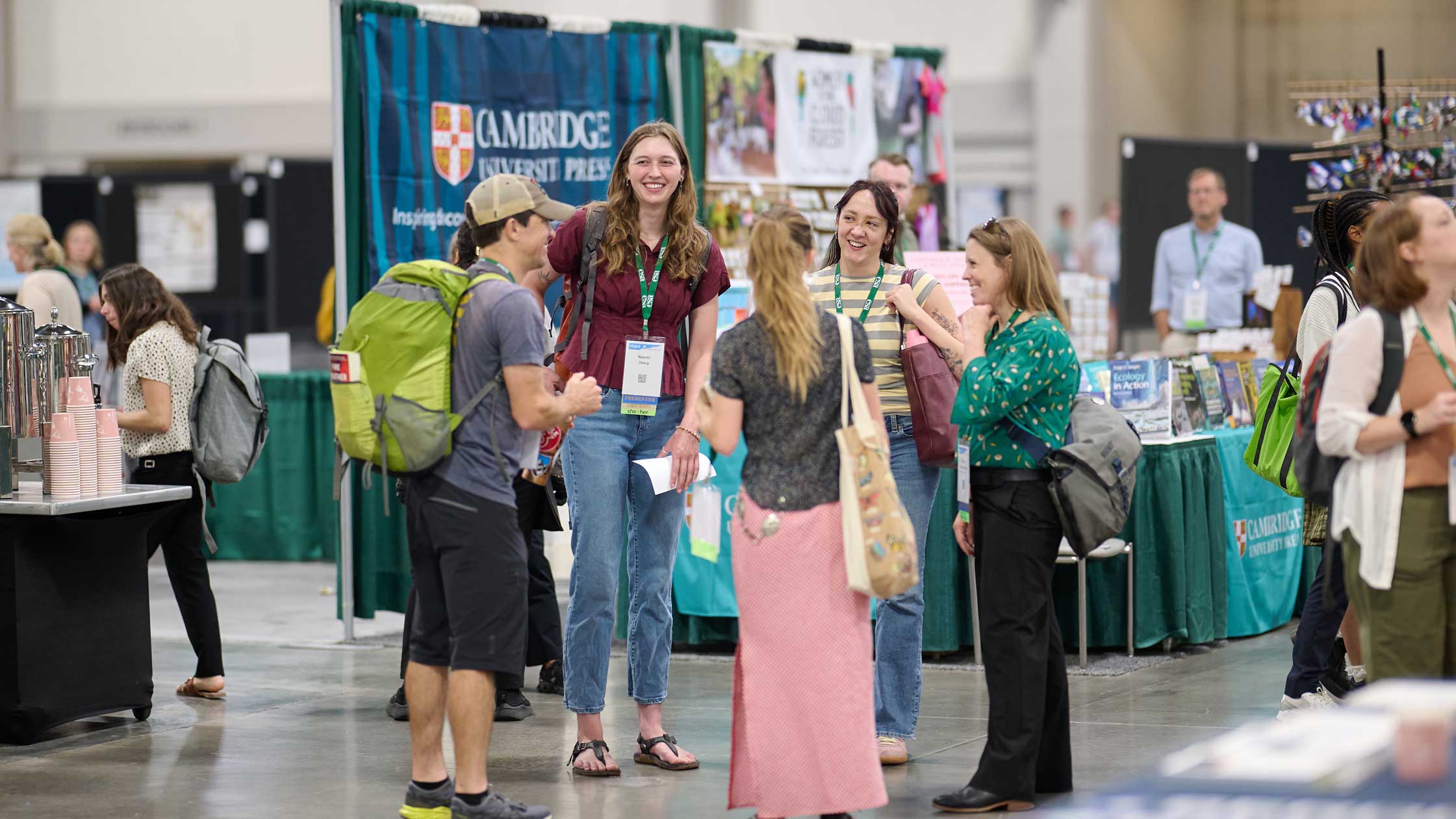 A group of attendees chat in the exhibit hall at the conference center.